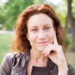 smiling lady touching face posing camera city park